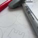 Prototyp gryplanszowej narysowany ołówkiem a na nim są kolorowe flamastry.