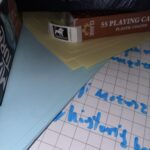 Kartka z opisem gry i karty klasyczne obok gry sen.