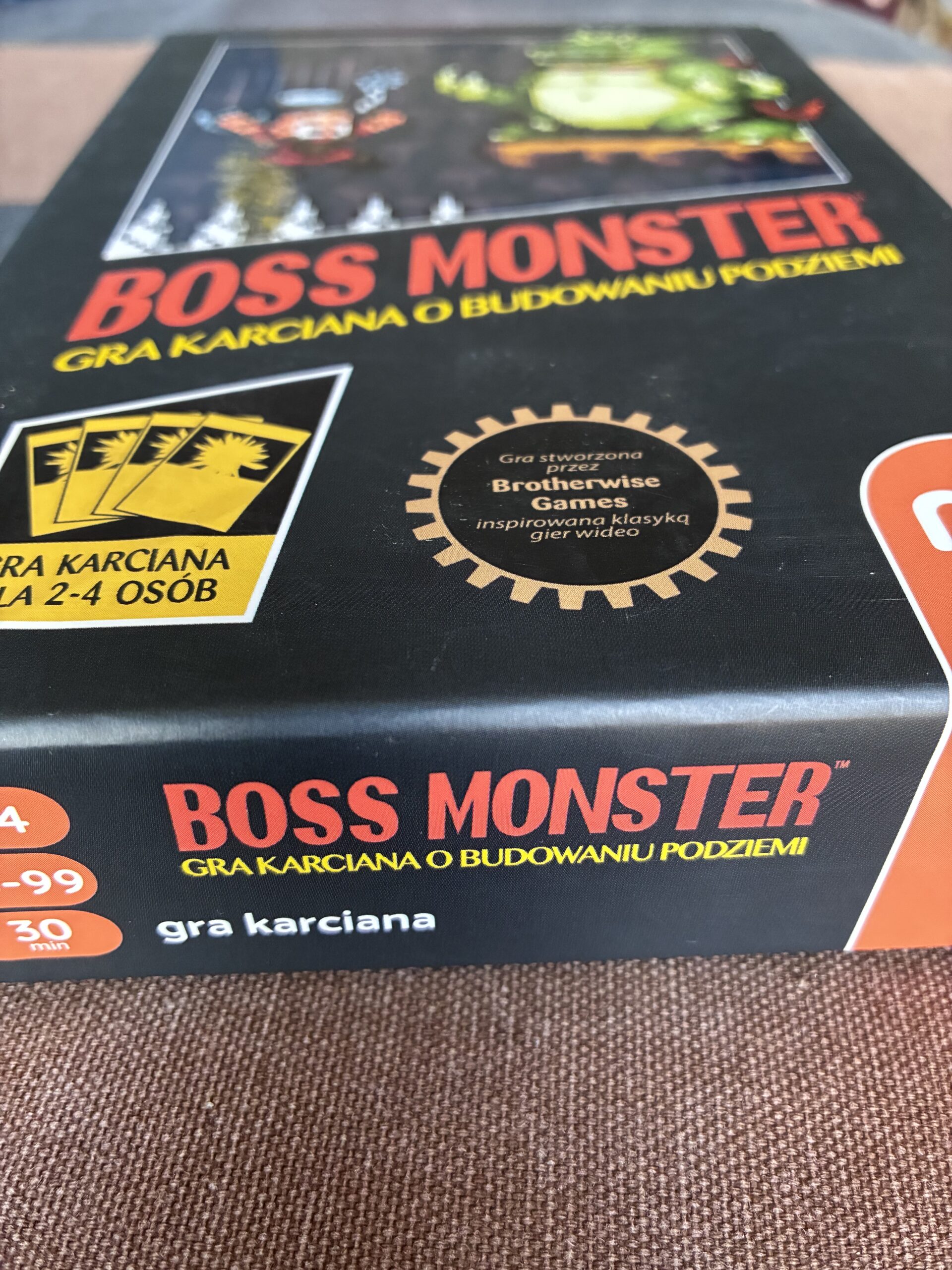 Pudełko gry boss monster ma czerwonym tle.