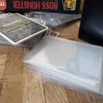 karty, osłonki na karty i pudełko gry boss monster.